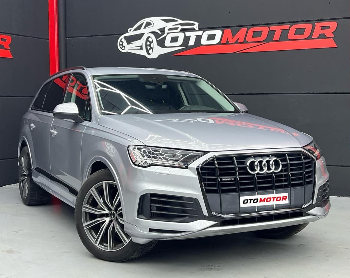 Audi Q7 55 TFSIe gris metalizado, vista frontal en showroom OtoMotor