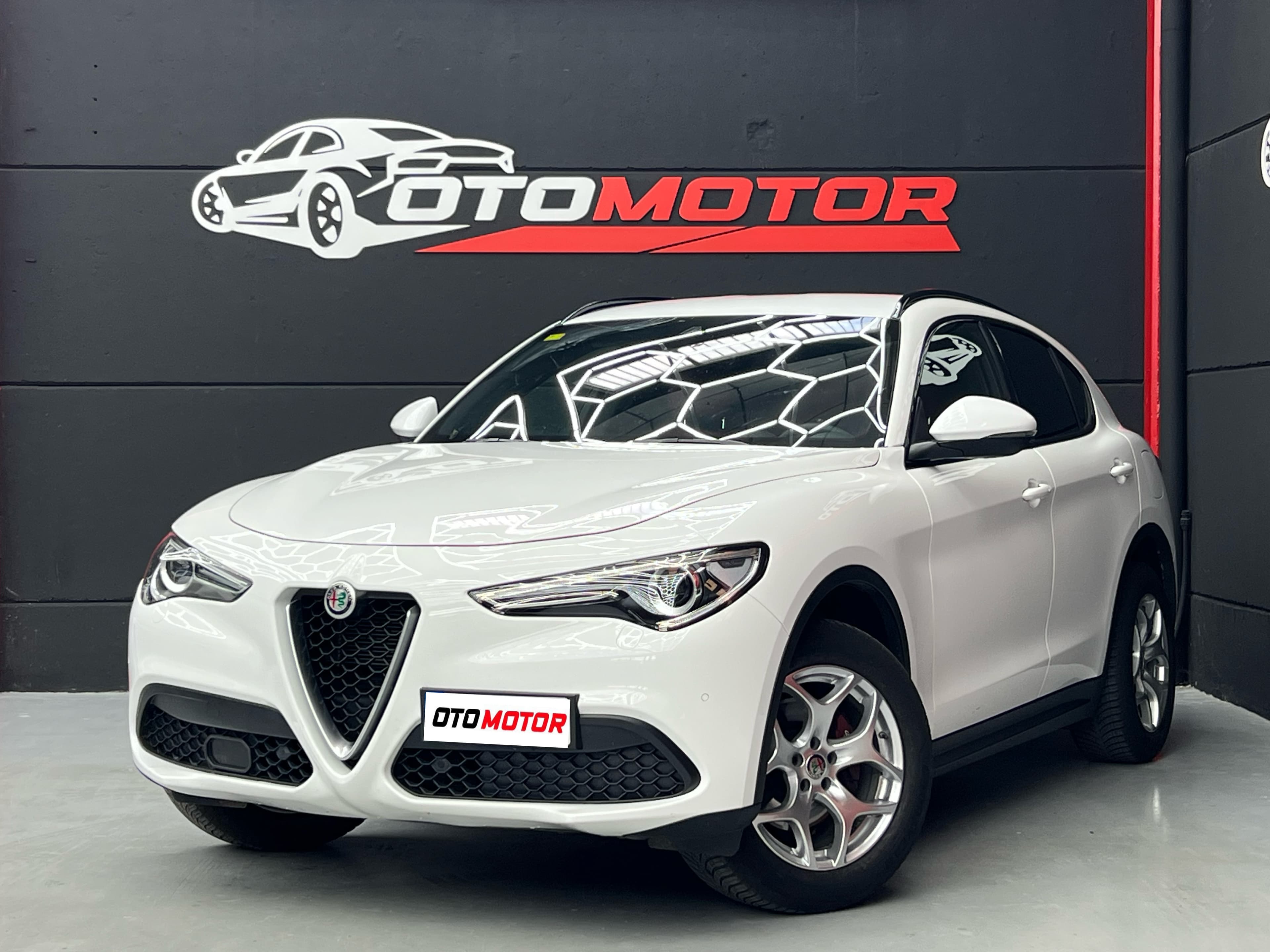 Alfa Romeo Stelvio Q4 blanco con interior rojo, en showroom OtoMotor