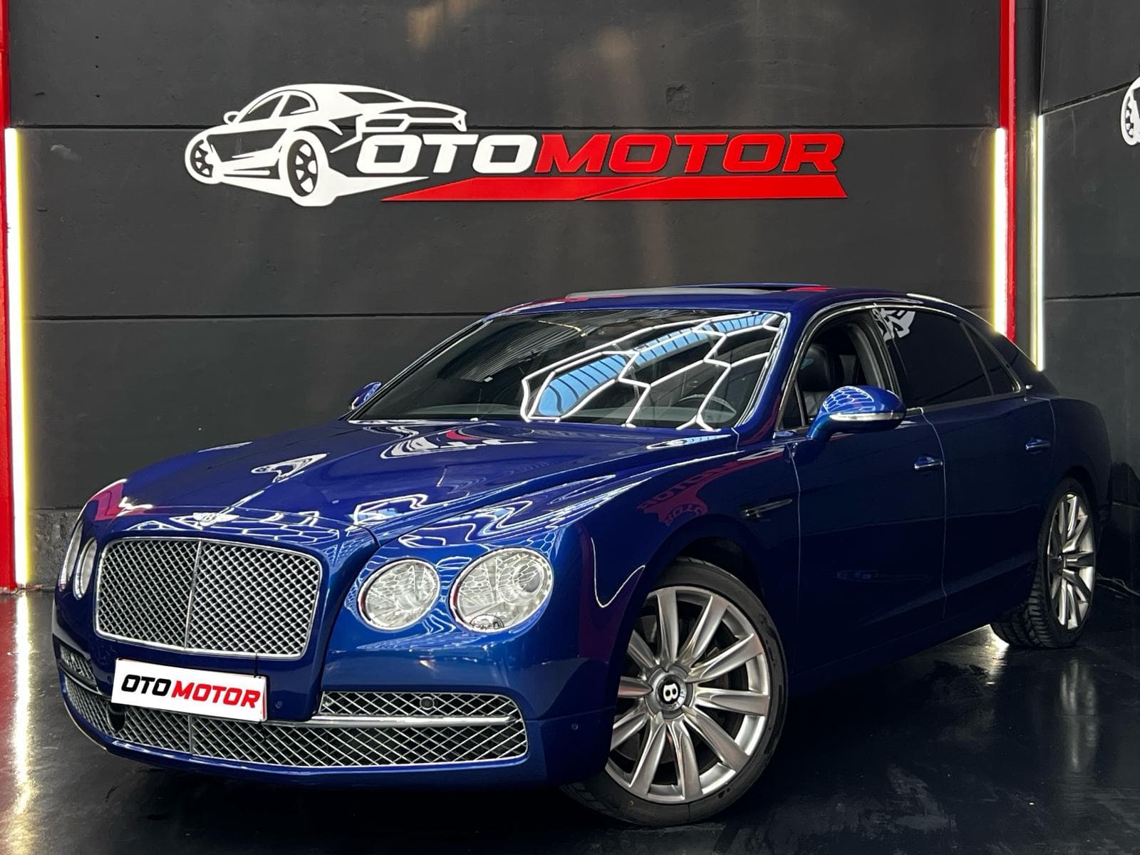 Bentley Flying Spur W12 azul intenso, vista frontal en showroom OtoMotor