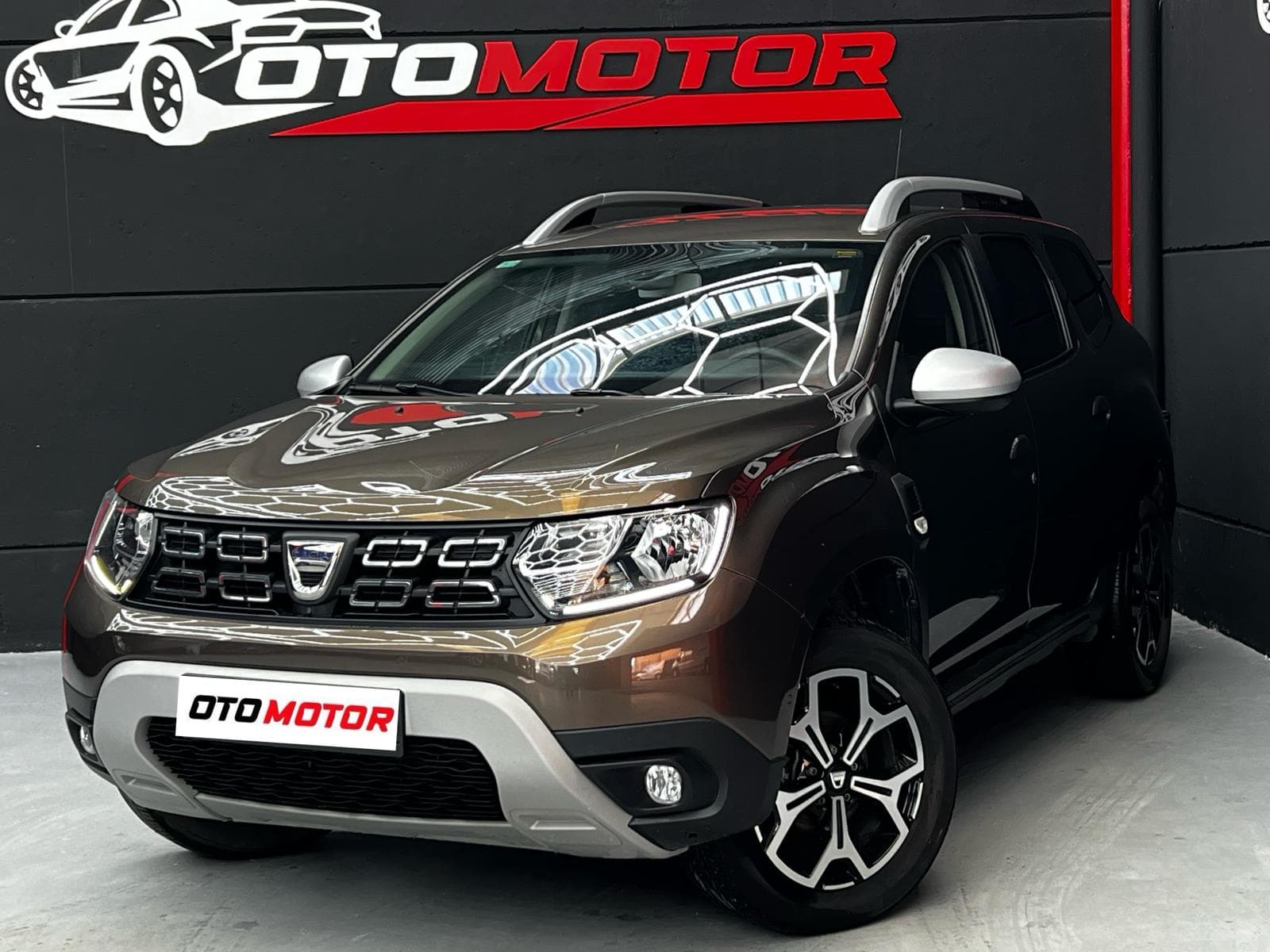 Dacia Duster Prestige marrón, vista delantera izquierda en showroom OtoMotor