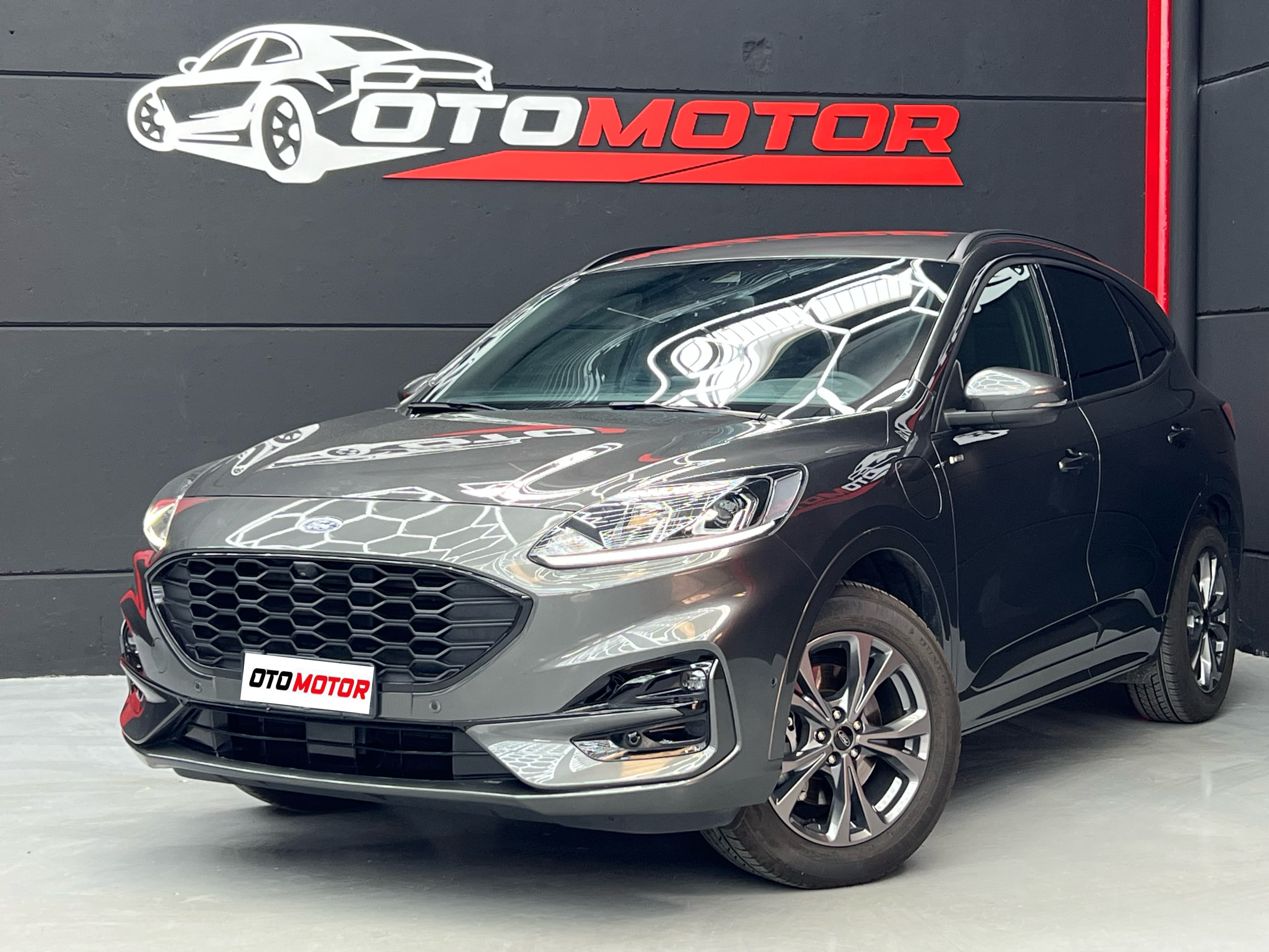 FORD Kuga ST Line PHEV gris, vista delantera izquierda en showroom OtoMotor