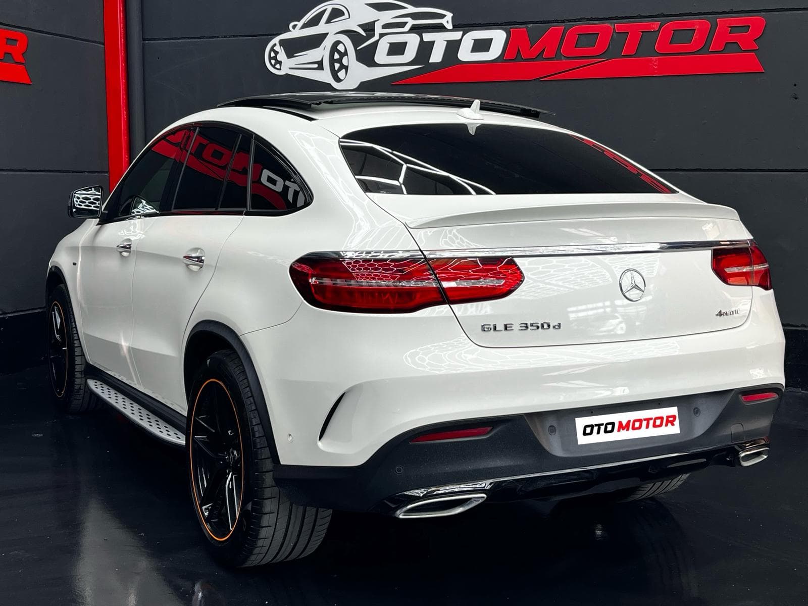 Mercedes GLE 350d Coupé blanco, vista trasera izquierda con detalles naranja