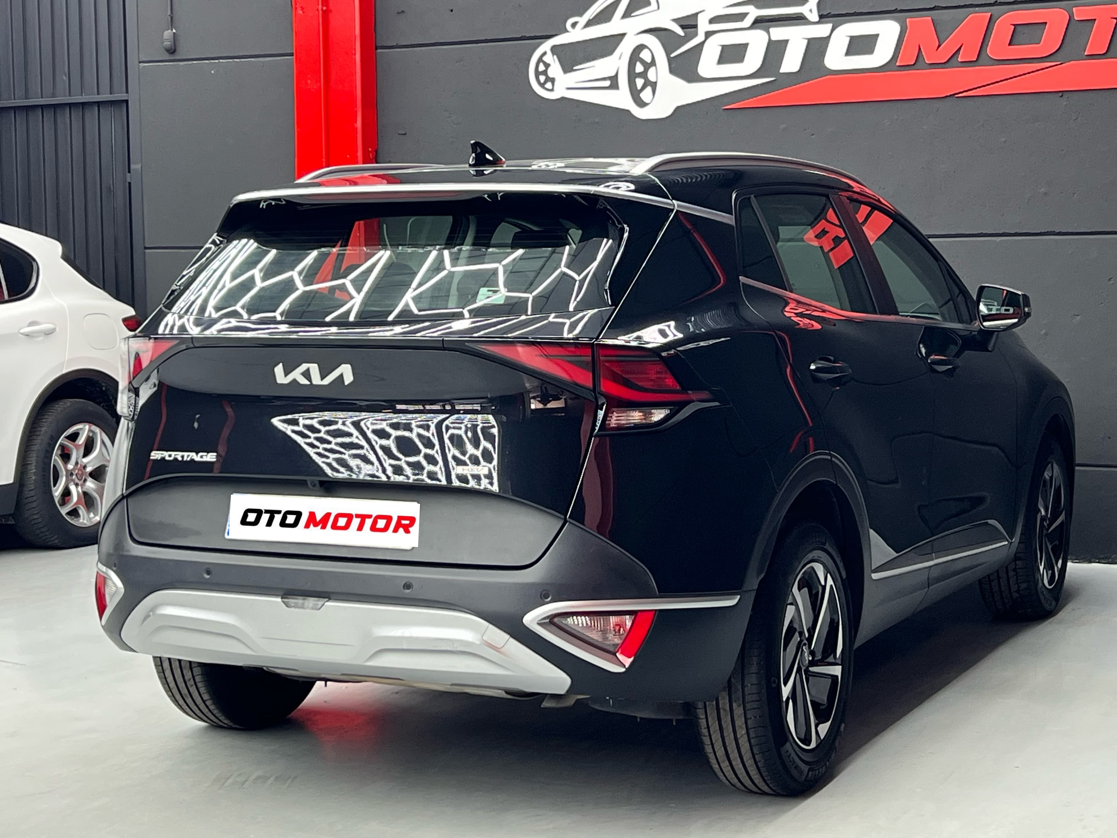 KIA Sportage negro 2023, vista trasera derecha con badge SPORTAGE