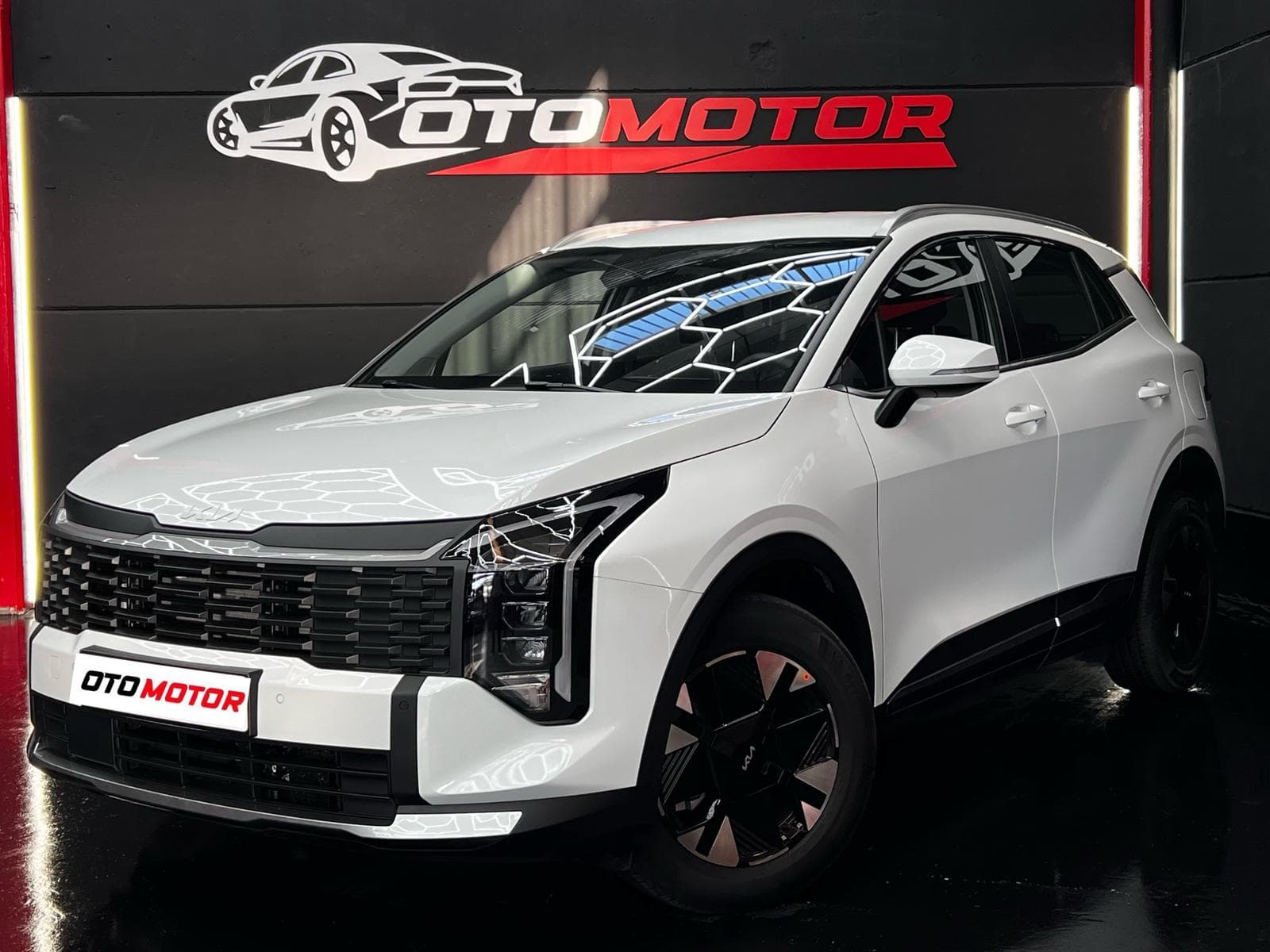 KIA Sportage HEV 2026 blanco, vista delantera izquierda en showroom OtoMotor