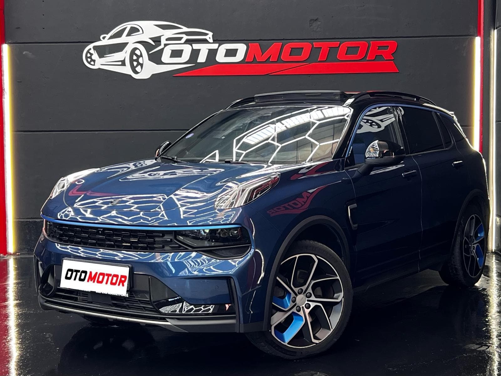 Lynk & Co 01 PHEV 2023 azul, vista delantera izquierda en showroom OtoMotor