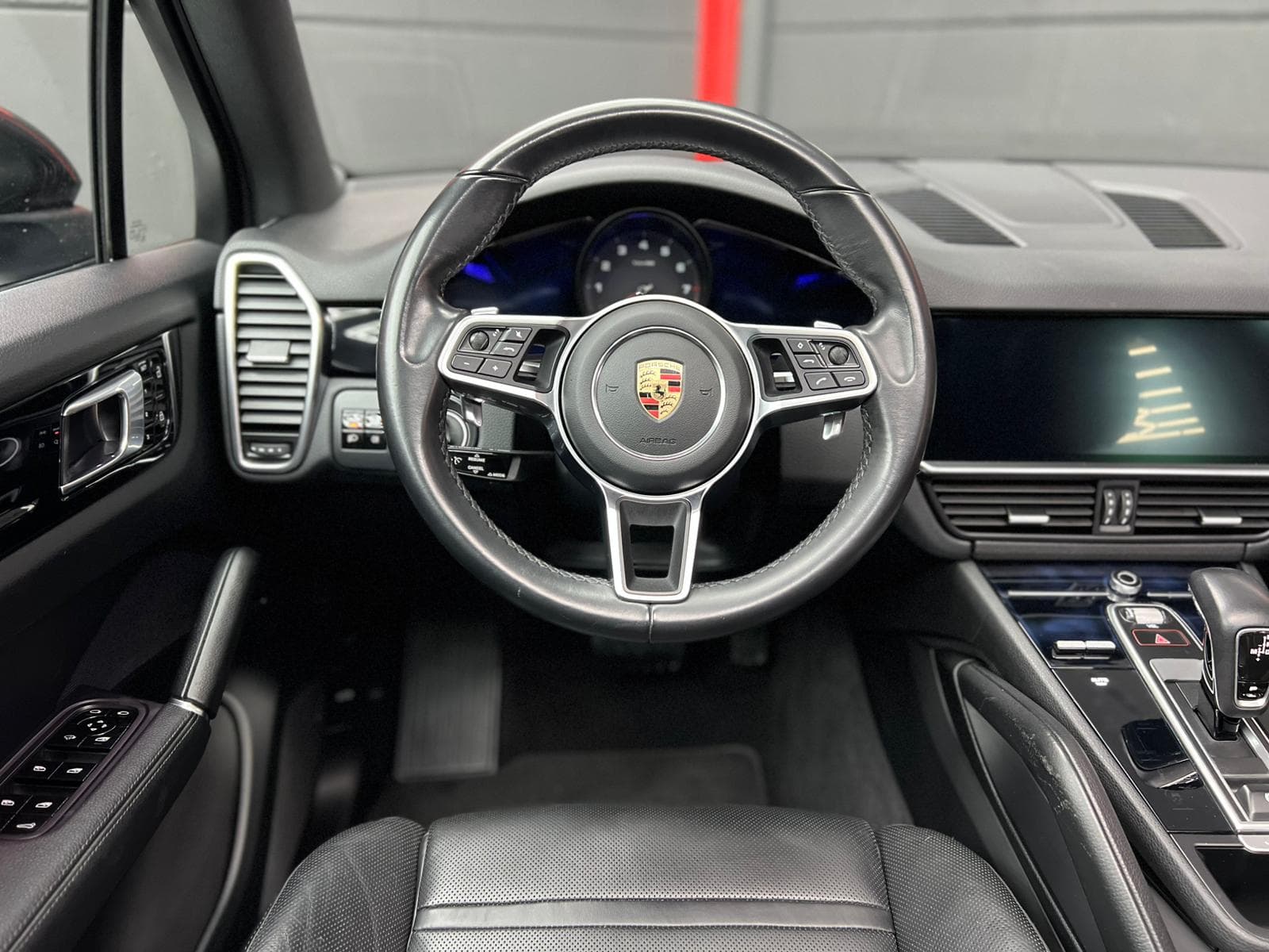Interior Porsche Cayenne negro 2020 con llantas doradas, salpicadero